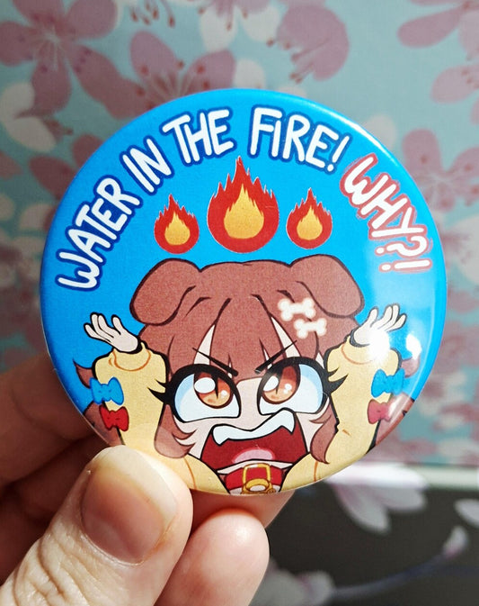 Button badge with cartoon character and text 'Water in the fire! What!?' held against a floral background.